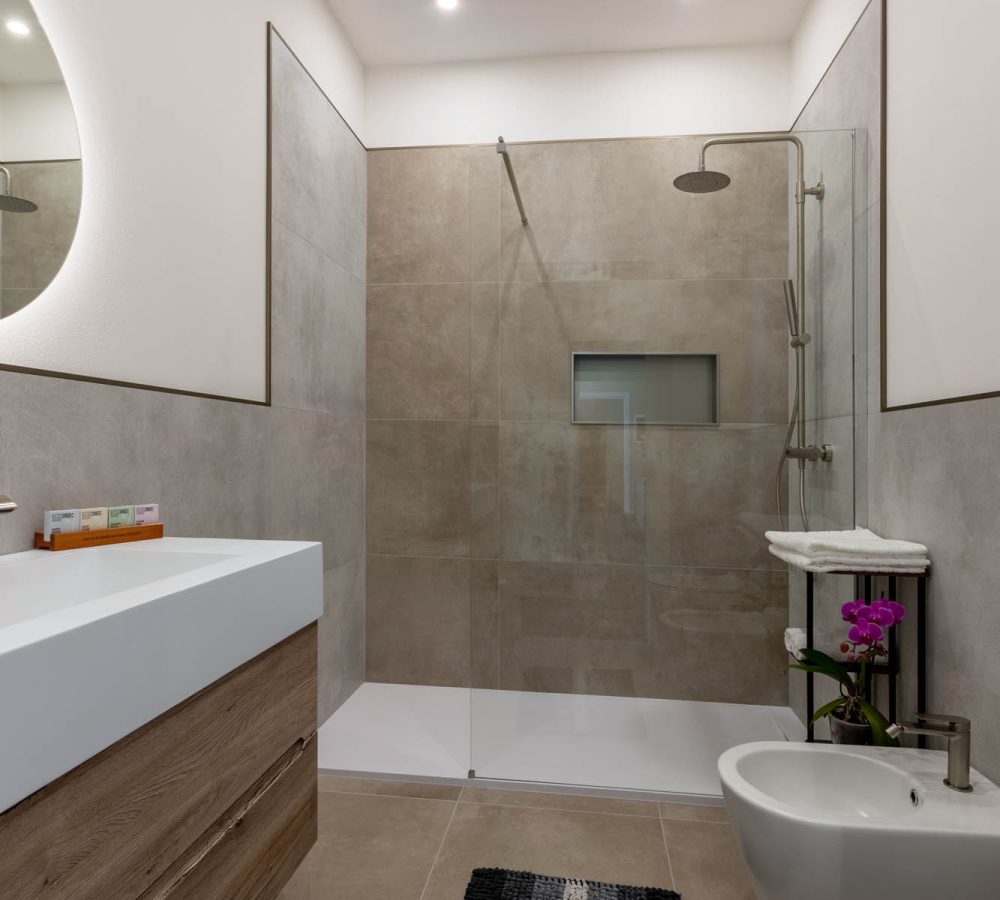 Bagno privato moderno con doccia walk-in finiture di pregio appartamenti di lusso.